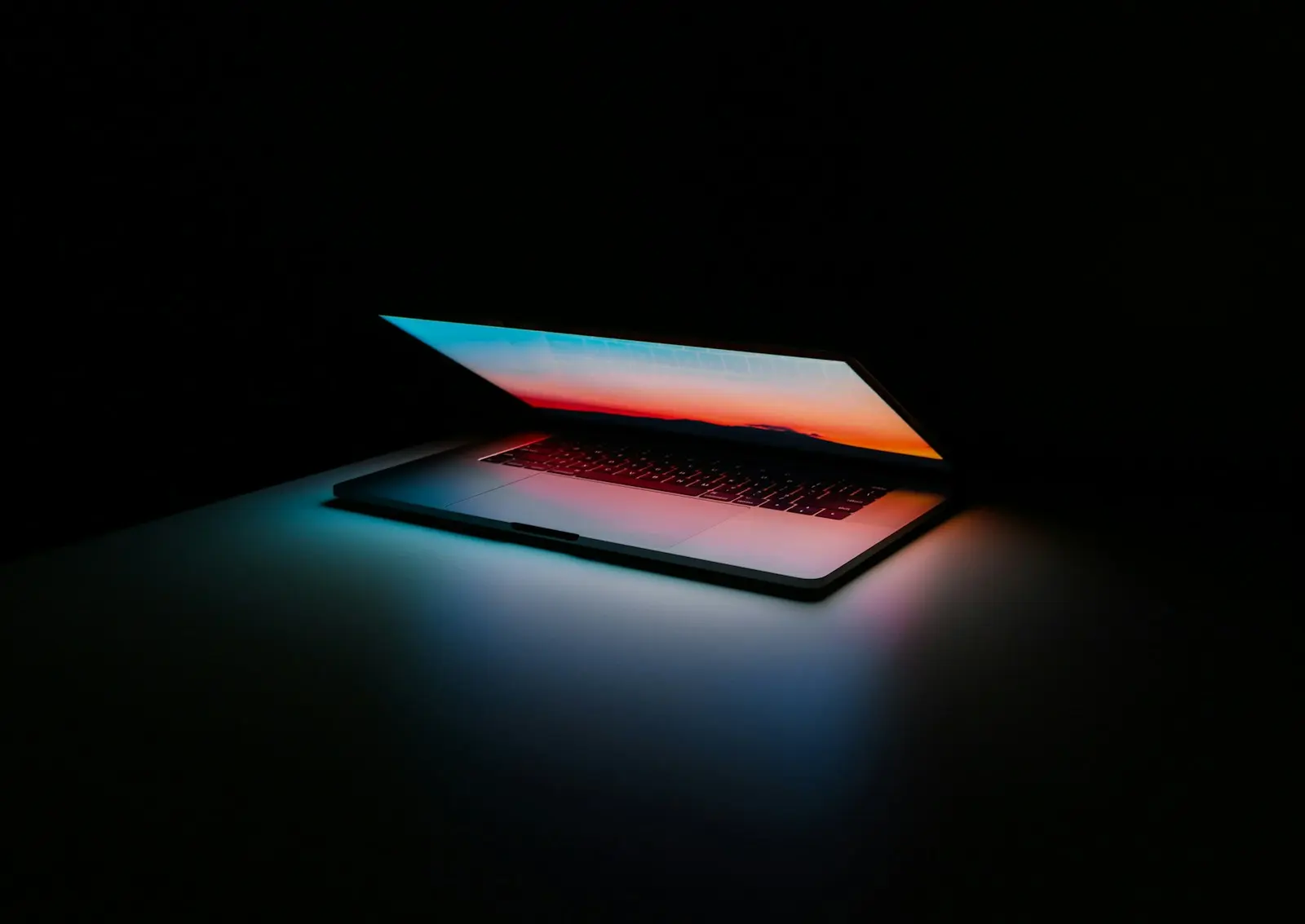 Portátil entreabierto iluminado en una habitación a oscuras