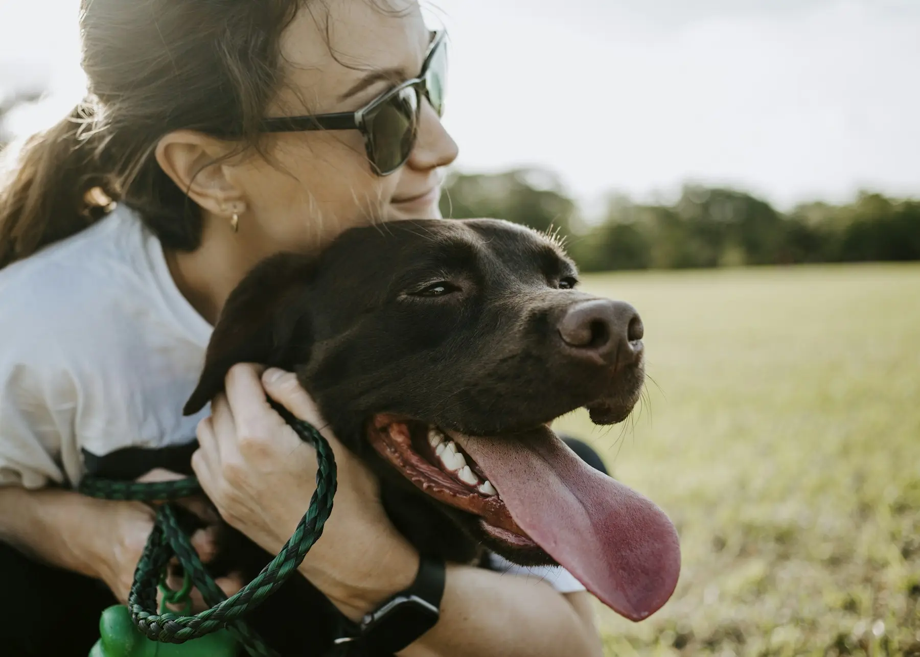 Mujer abrazando a su perro en el campo