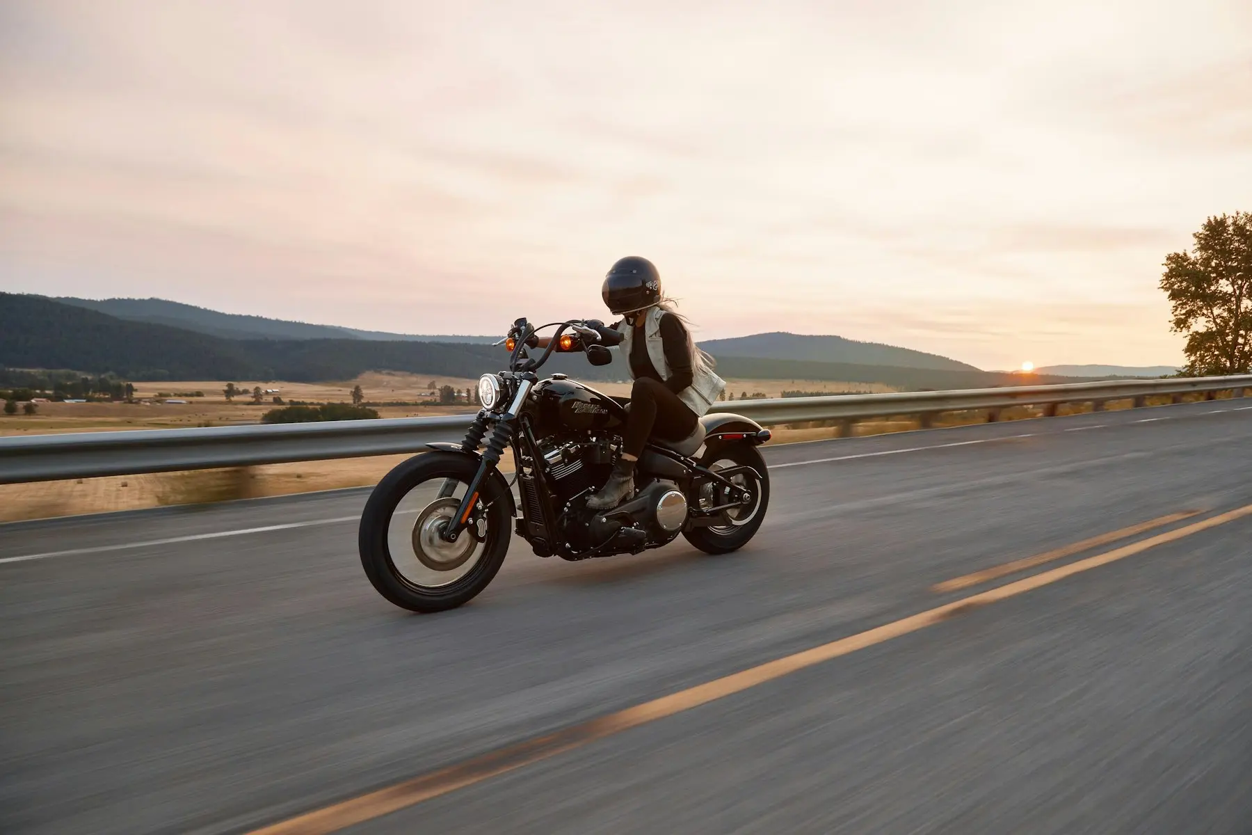 Motorista en una carretera abierta al atardecer